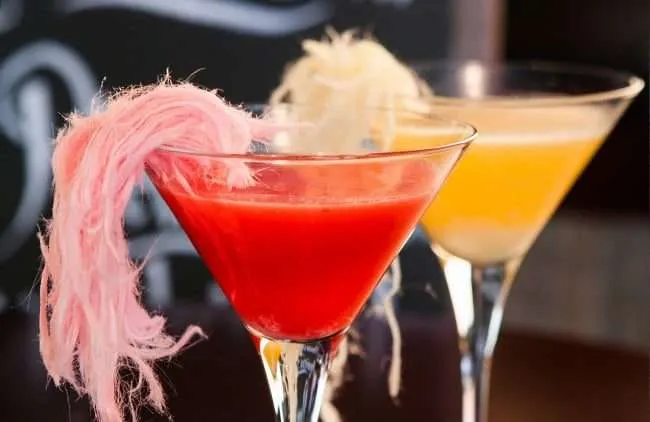 Red and yellow cocktail with candy floss